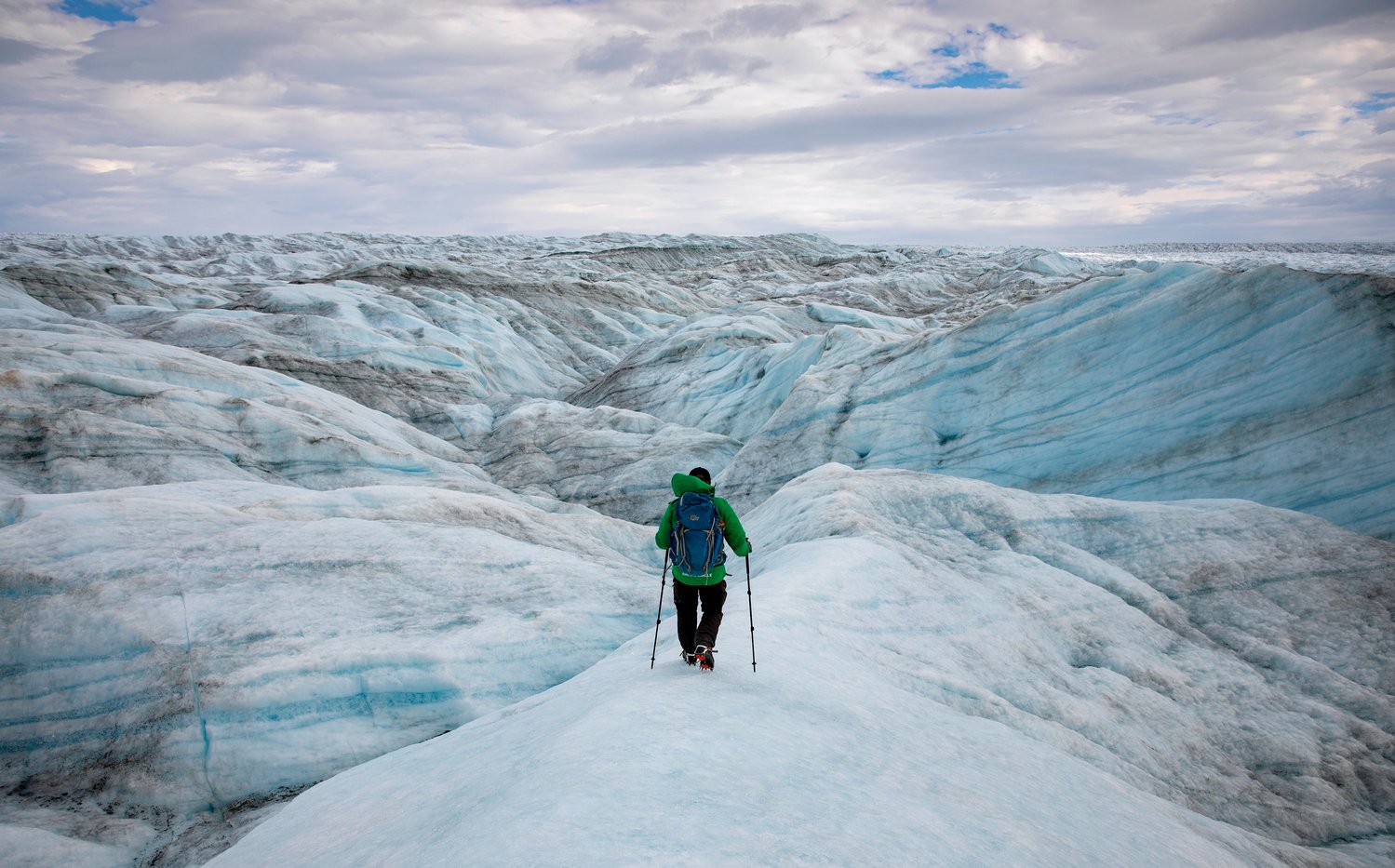 Adam Lyberth maneuvers his way around blue-and-white hills of  ice and snow on the Greenland ice sheet on Friday, August 13, 2021. An Inuit shaman, he says he’s walked on the ice more than 3,000 times, and that it changes every day. Lauren Petracca/Staff